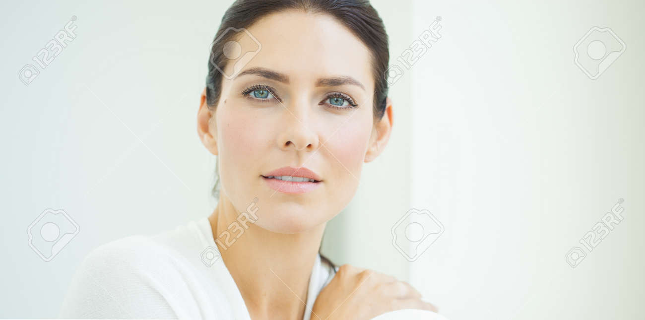 Beautiful natural European woman sitting in daylight at window with serene expresssion. Blue eyes and dark hair. - 45643610 Beautiful natural European woman sitting in daylight at window with serene expresssion. Blue eyes and dark hair. - 45643610