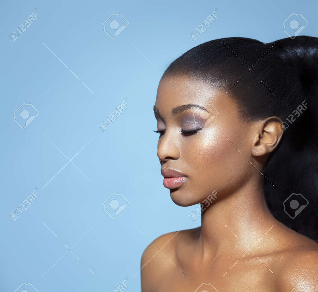 Portrait of beautiful serene African girl with closed eyes over blue studio background. African beauty with makeup and long hair. - 45872972 Portrait of beautiful serene African girl with closed eyes over blue studio background. African beauty with makeup and long hair. - 45872972
