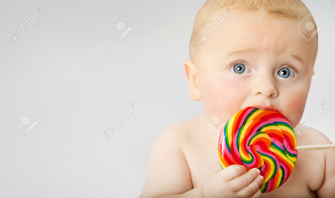 Five months old little baby boy with large lollypop. - 52142864 Five months old little baby boy with large lollypop. - 52142864
