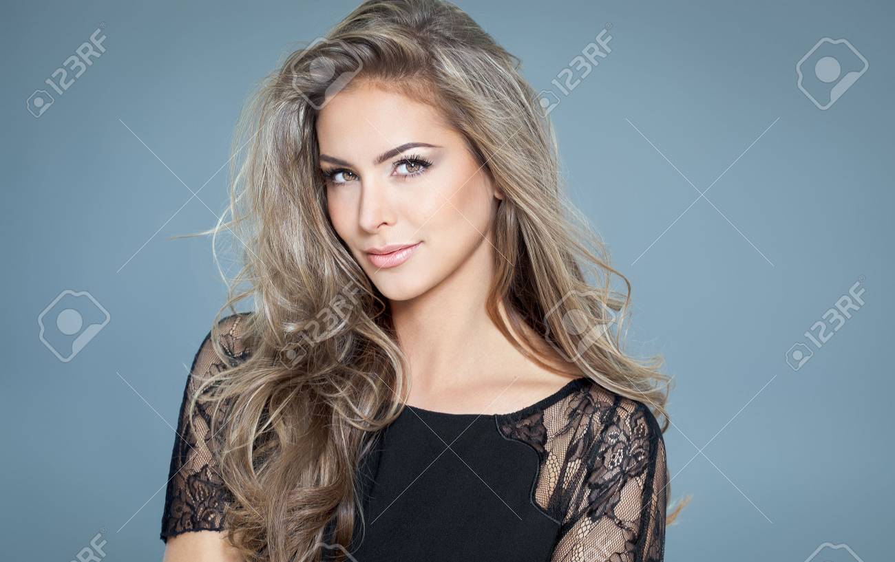 Young beautiful woman with long hair and highlights posing in black silk lace top. Smiling fashionable woman. - 65056686 Young beautiful woman with long hair and highlights posing in black silk lace top. Smiling fashionable woman. - 65056686