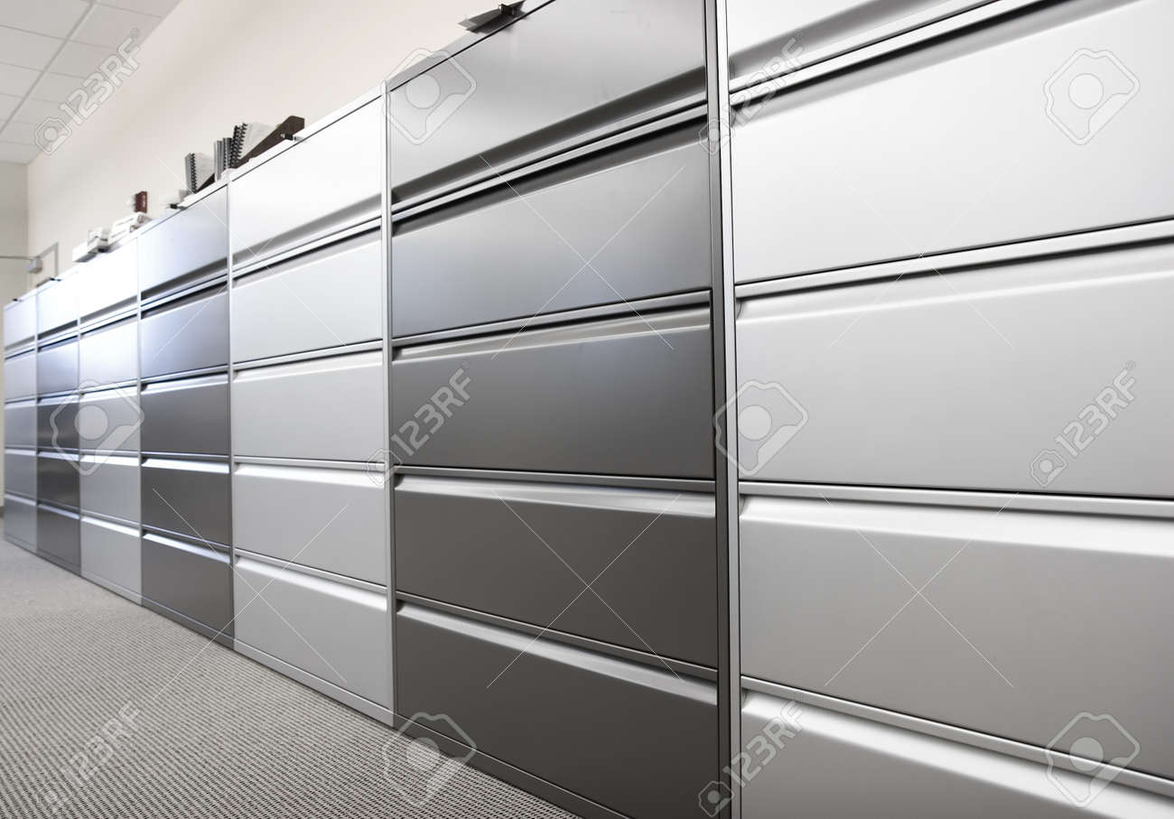 long row of large filing cabinets in an office or hospital stock long row of large filing cabinets in an office or hospital stock