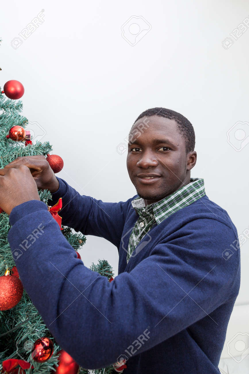 Black People Decorating For Christmas black man decorating the christmas tree stock photo, picture and Black People Decorating For Christmas black man decorating the christmas tree stock photo, picture and
