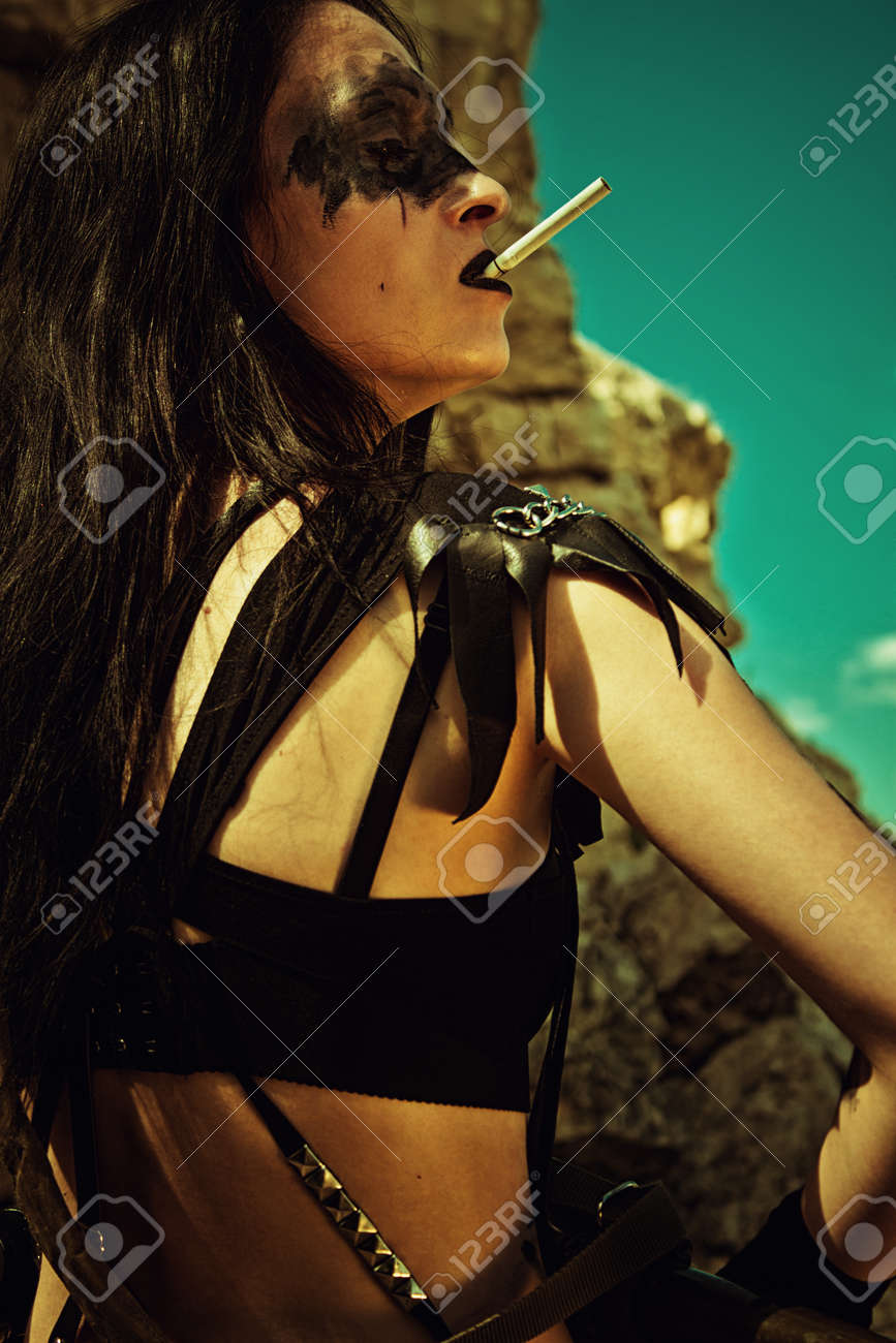 魅惑的な無慈悲な少女 Cigarrete と荒れ地のポーズの武器 の写真素材 画像素材 Image