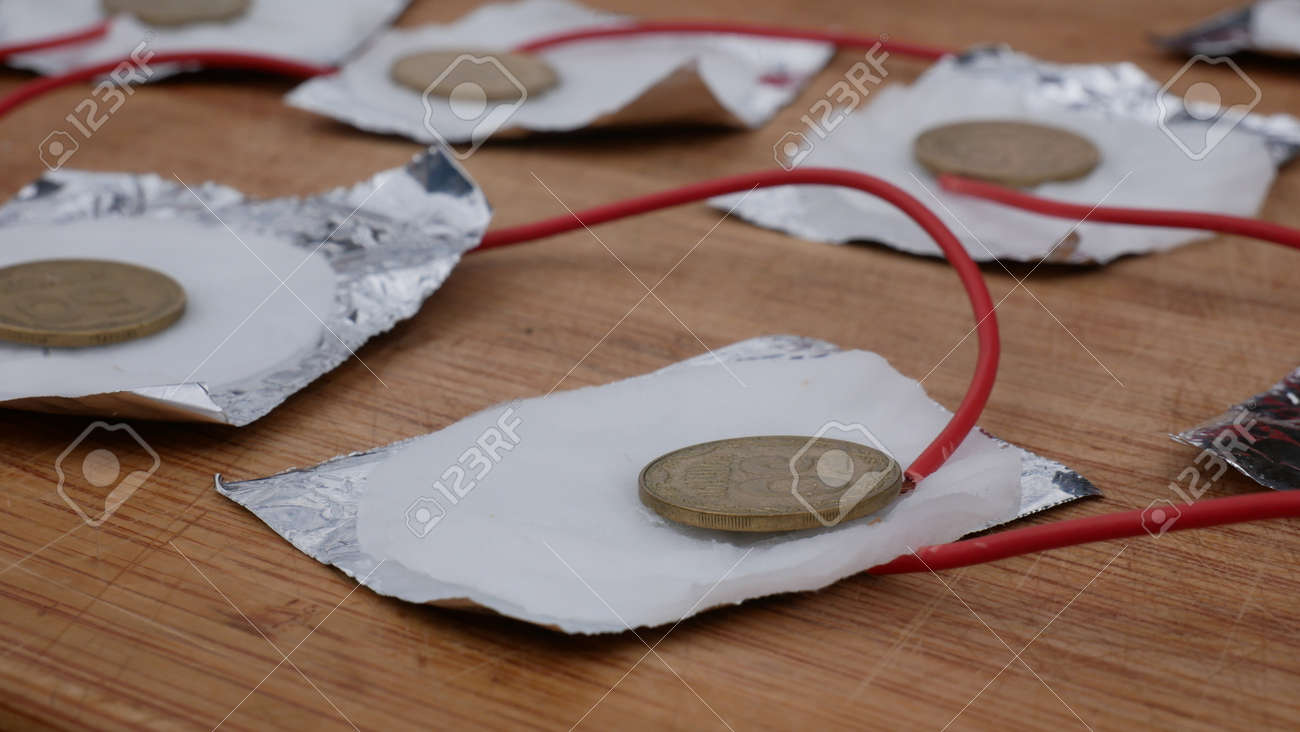 호일 황동 동전 소금 용액으로 전기를 생산하고 주방에서 직접 만든 소금 전지에서 탈지면 화학 실험 로열티 무료 사진, 그림, 이미지  그리고 스톡포토그래피. Image 169965288