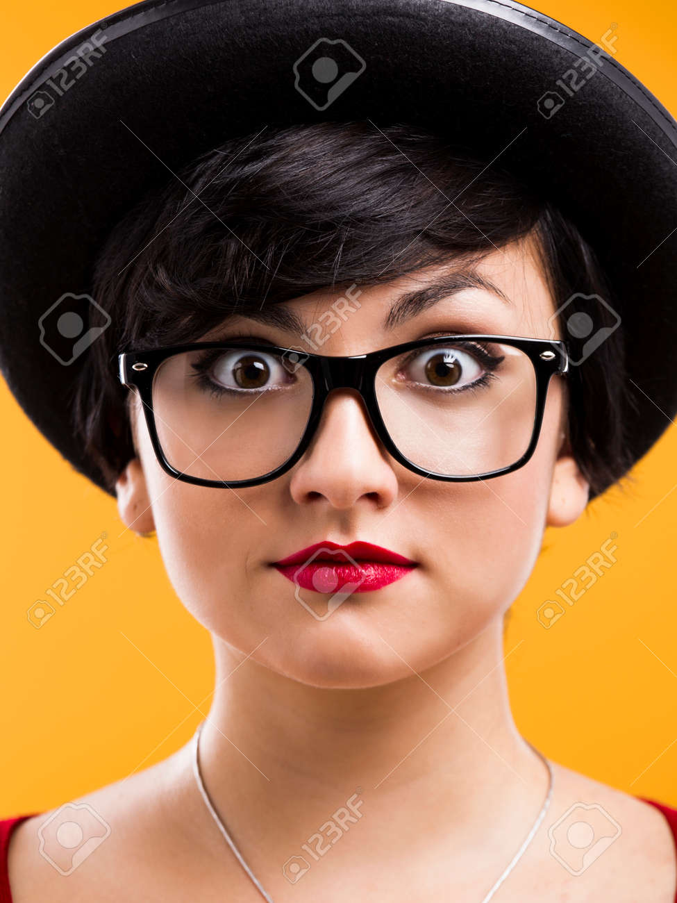 Beautiful Girl With A Astonished Expression Wearing A Hat And Nerd Glasses Over A Yellow Beautiful Girl With A Astonished Expression Wearing A Hat And Nerd Glasses Over A Yellow