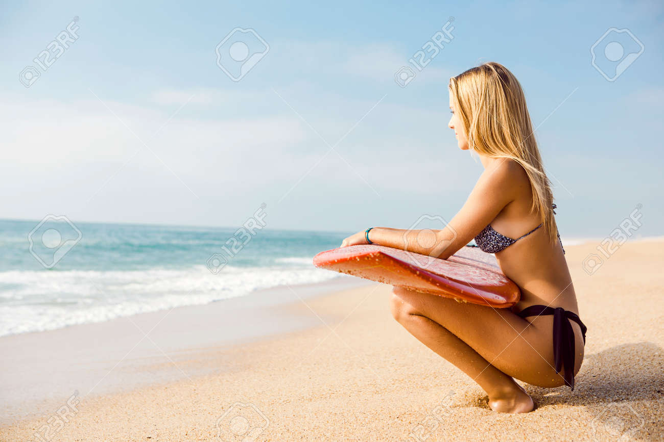 美しく セクシーなサーファーガール サーフボードを押しながら波をチェック の写真素材 画像素材 Image