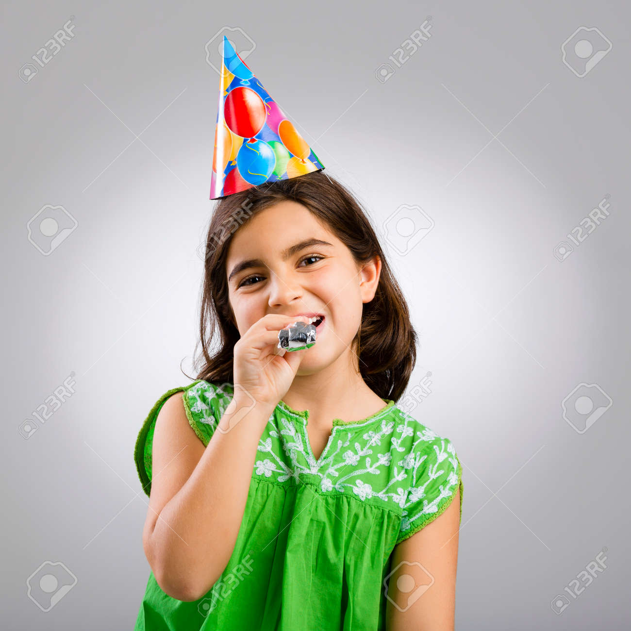 彼女の誕生日にパーティー帽子をかぶっている女の子のスタジオ ポートレート の写真素材 画像素材 Image