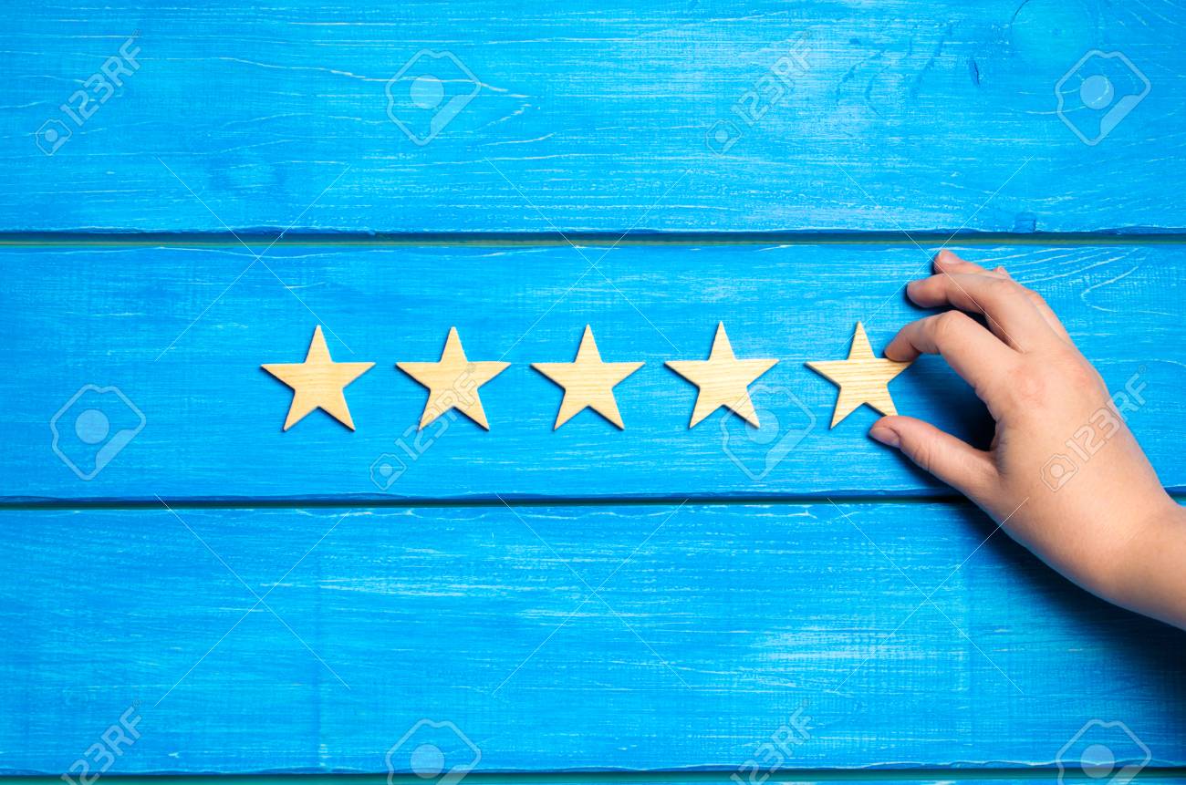 The hand puts the fifth star. The critic determines the rating of the restaurant, hotel, institution. - 103699972 The hand puts the fifth star. The critic determines the rating of the restaurant, hotel, institution. - 103699972