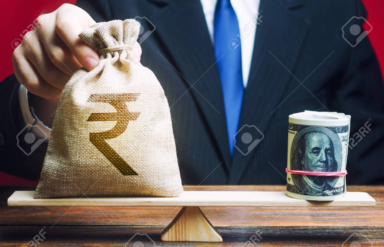 사업가는 달러 롤 반대 저울에 인도 루피 돈 가방을 넣습니다. 환율, 경제 지표의 비교. 저축 인플레이션 방지. 외화채권 투자. 로열티  무료 사진, 그림, 이미지 그리고 스톡포토그래피. Image 139392369