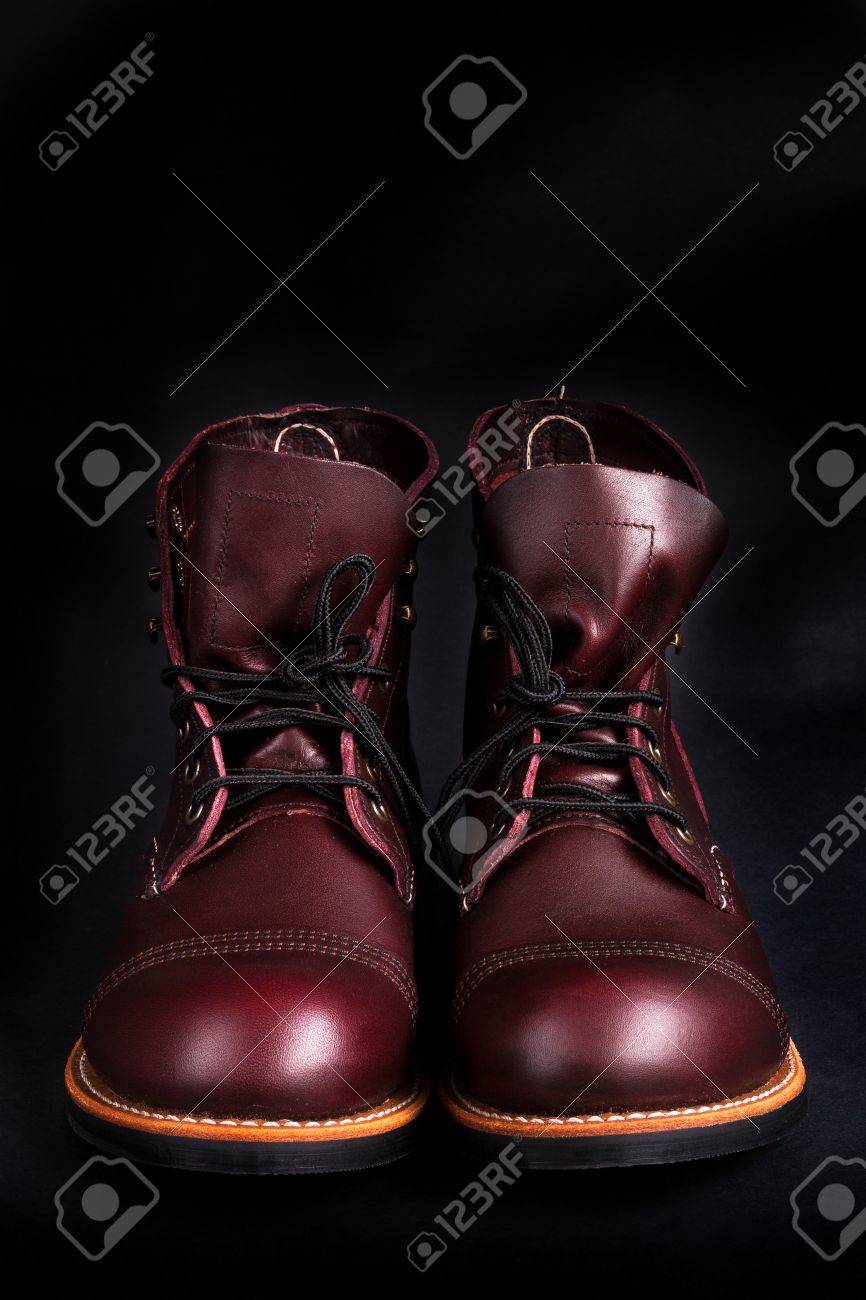 Botas altas. De moda los zapatos de cuero para hombre marrón sobre fondo negro. Vista trasera Botas altas. De moda los zapatos de cuero para hombre marrón sobre fondo negro. Vista trasera