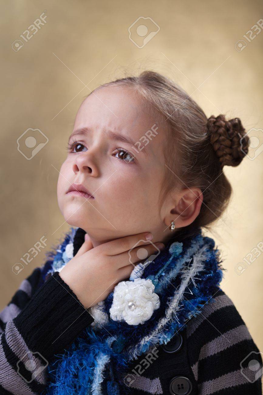 Little girl with sore throat in flu season touching her neck - 18494344 Little girl with sore throat in flu season touching her neck - 18494344