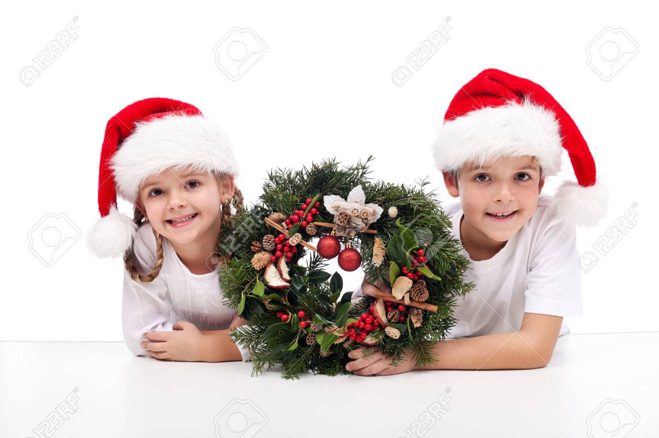 Kids with traditional advent wreath wearing santa hats - 22426647 Kids with traditional advent wreath wearing santa hats - 22426647