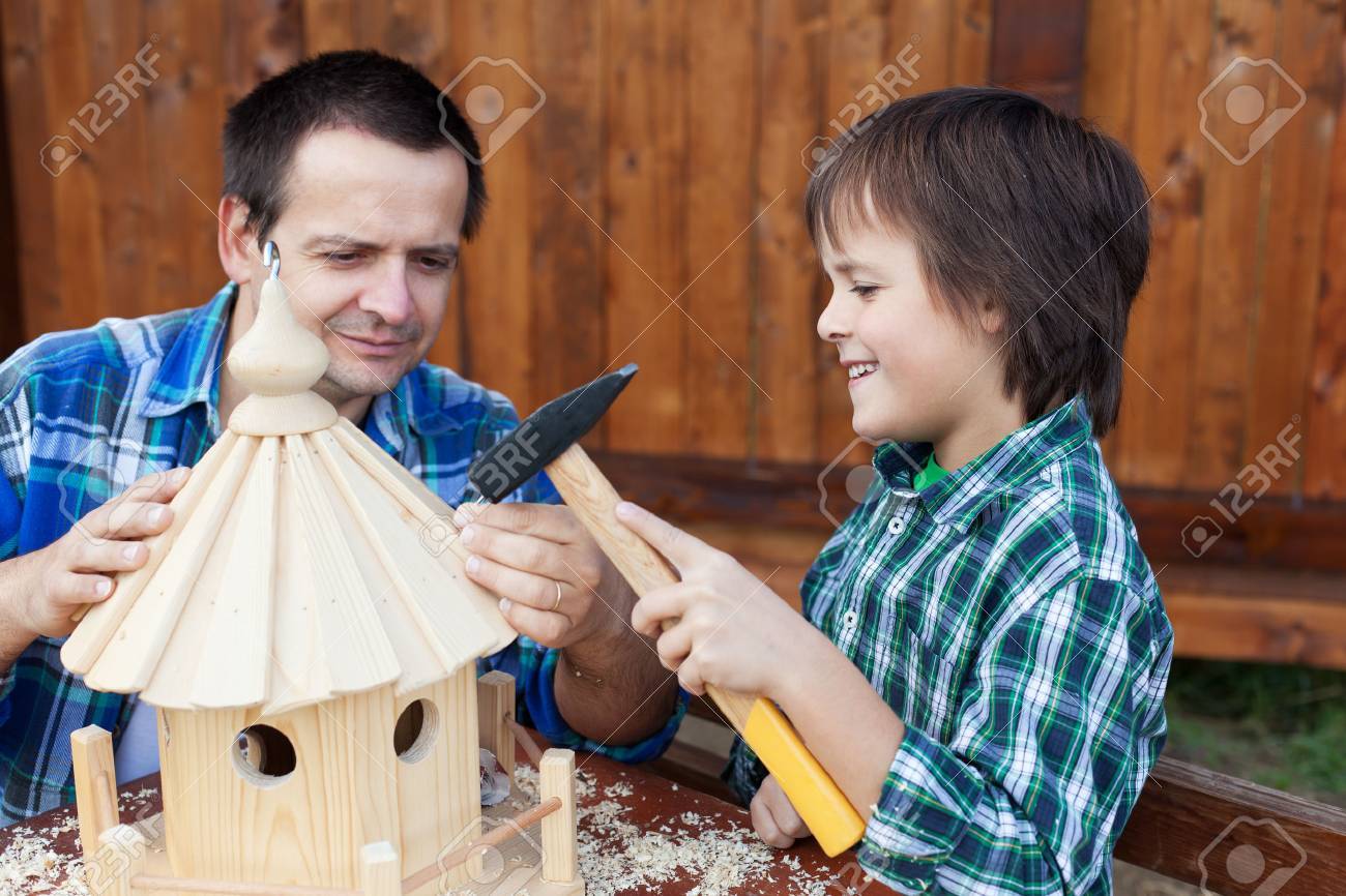 Father and son building a bird house or feeder for the winter time - 24081259 Father and son building a bird house or feeder for the winter time - 24081259