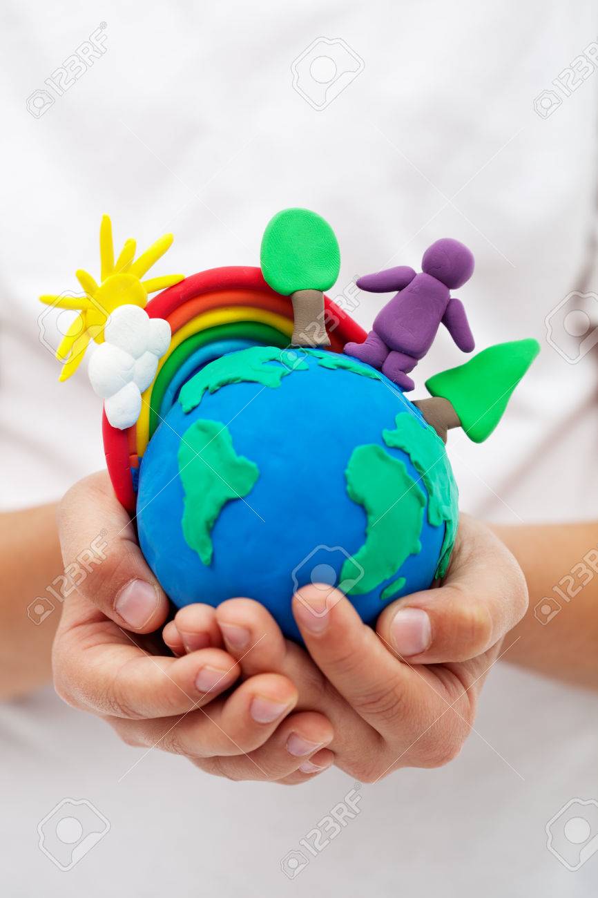 Modelling clay earth with rainbow and trees in child hands - 26398515 Modelling clay earth with rainbow and trees in child hands - 26398515