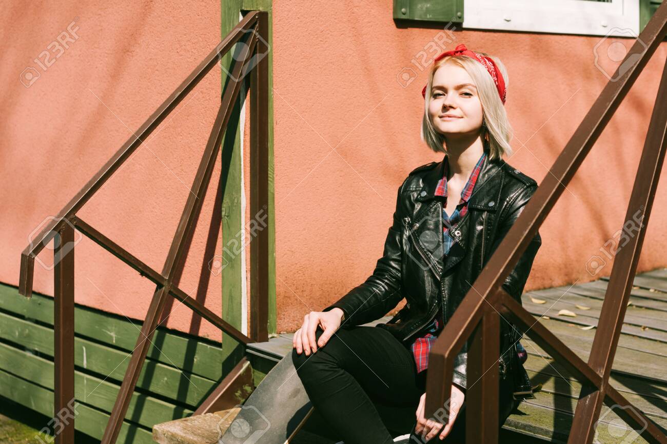 Teenage Female Hipster In A Biker Jacket With A Hairstyle Sits