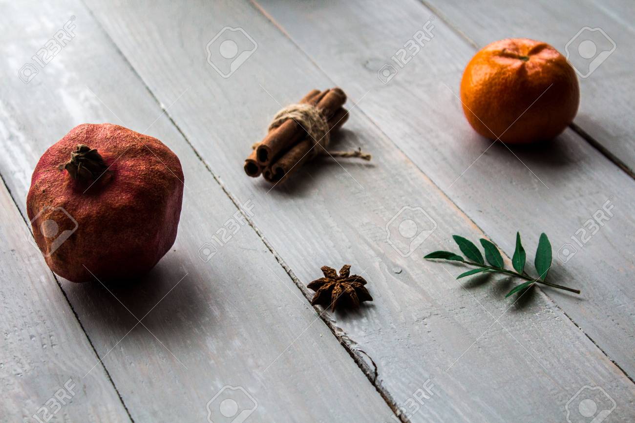Pomegranate Mandarin Cinnamon And Onyx On The Wooden Background Stock Photo Picture And Royalty Free Image Image 97640220