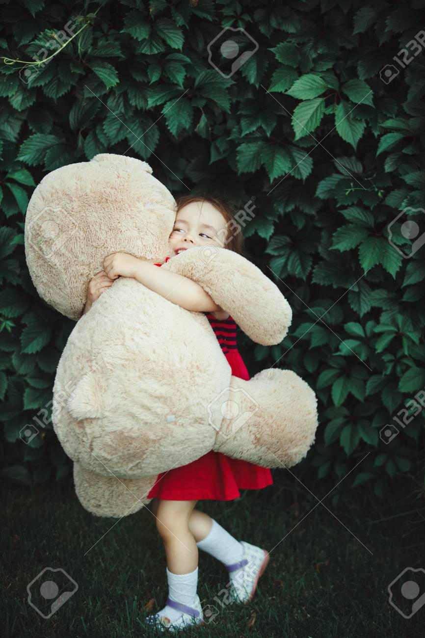 girl hugging a big teddy bear