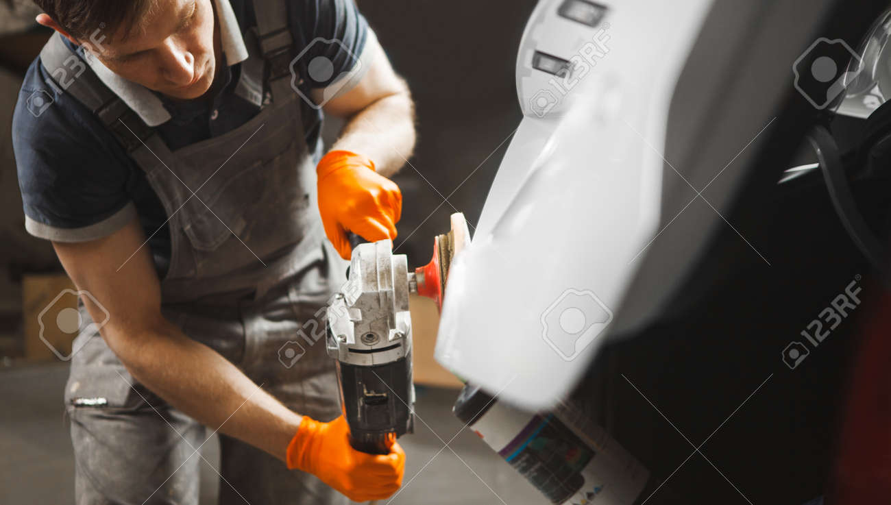 Car detailing. Close up of man with orbital polisher in auto repair shop. Bodywork maintenance. - 153075212 Car detailing. Close up of man with orbital polisher in auto repair shop. Bodywork maintenance. - 153075212