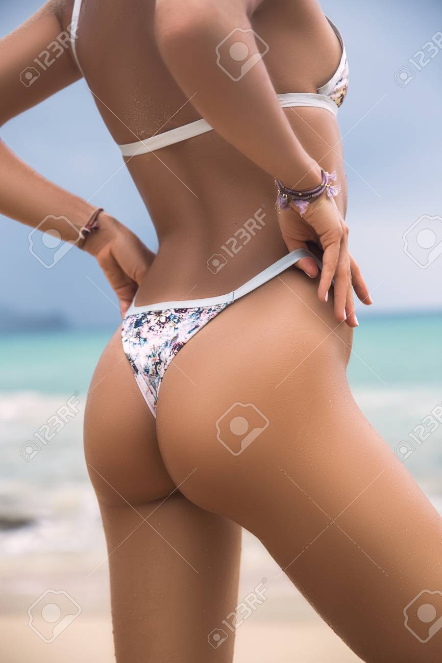海のビーチで水着姿の美女の裏スリムなクローズ アップの美しい高級 セクシーな日焼けした体は 平らな胃 完璧な図 熱帯の島の残りの部分します セクシーなお尻 の写真素材 画像素材 Image