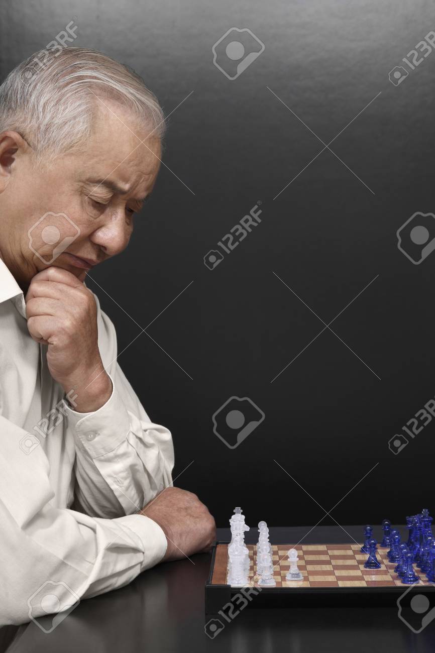 Senior man planning his next chess move, Stock image