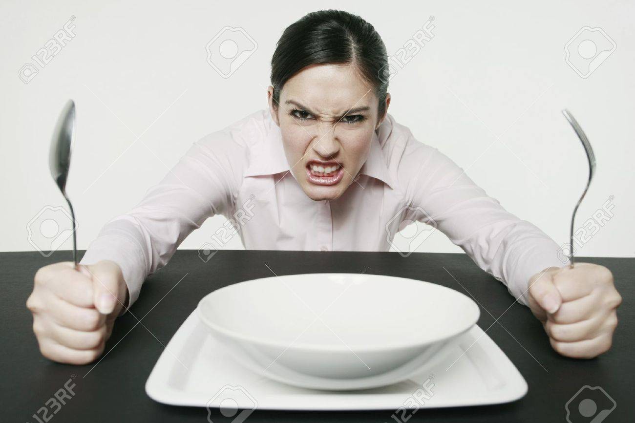 Businesswoman sitting at table looking angry - 10572559 Businesswoman sitting at table looking angry - 10572559