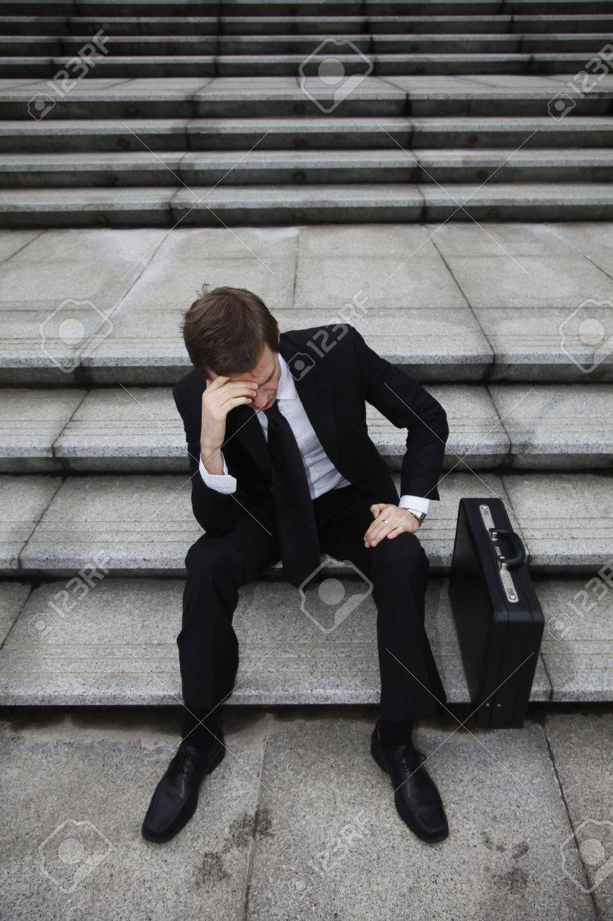 Businessman sitting on stairs looking depressed - 13441096 Businessman sitting on stairs looking depressed - 13441096