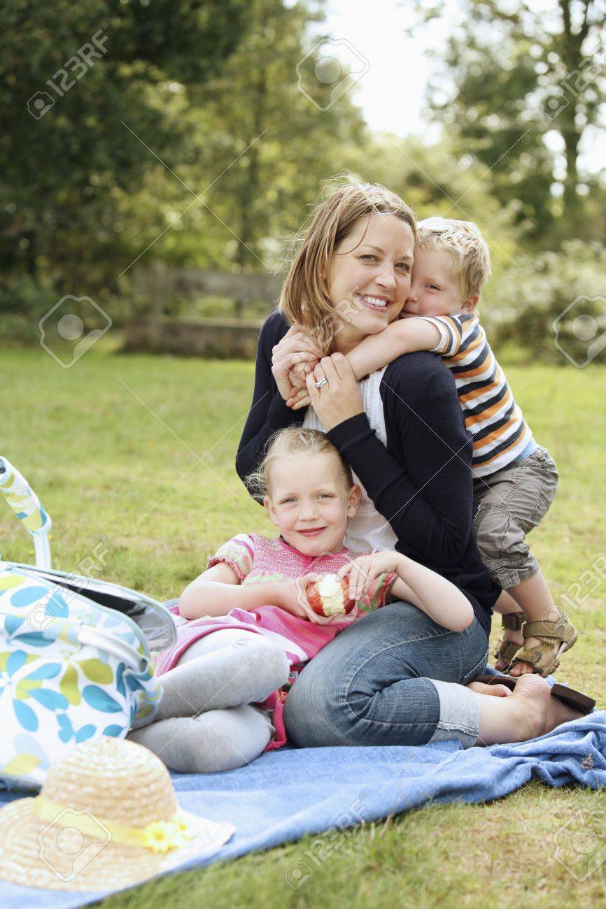 Woman and children having a picnic at the park - 13568616 Woman and children having a picnic at the park - 13568616