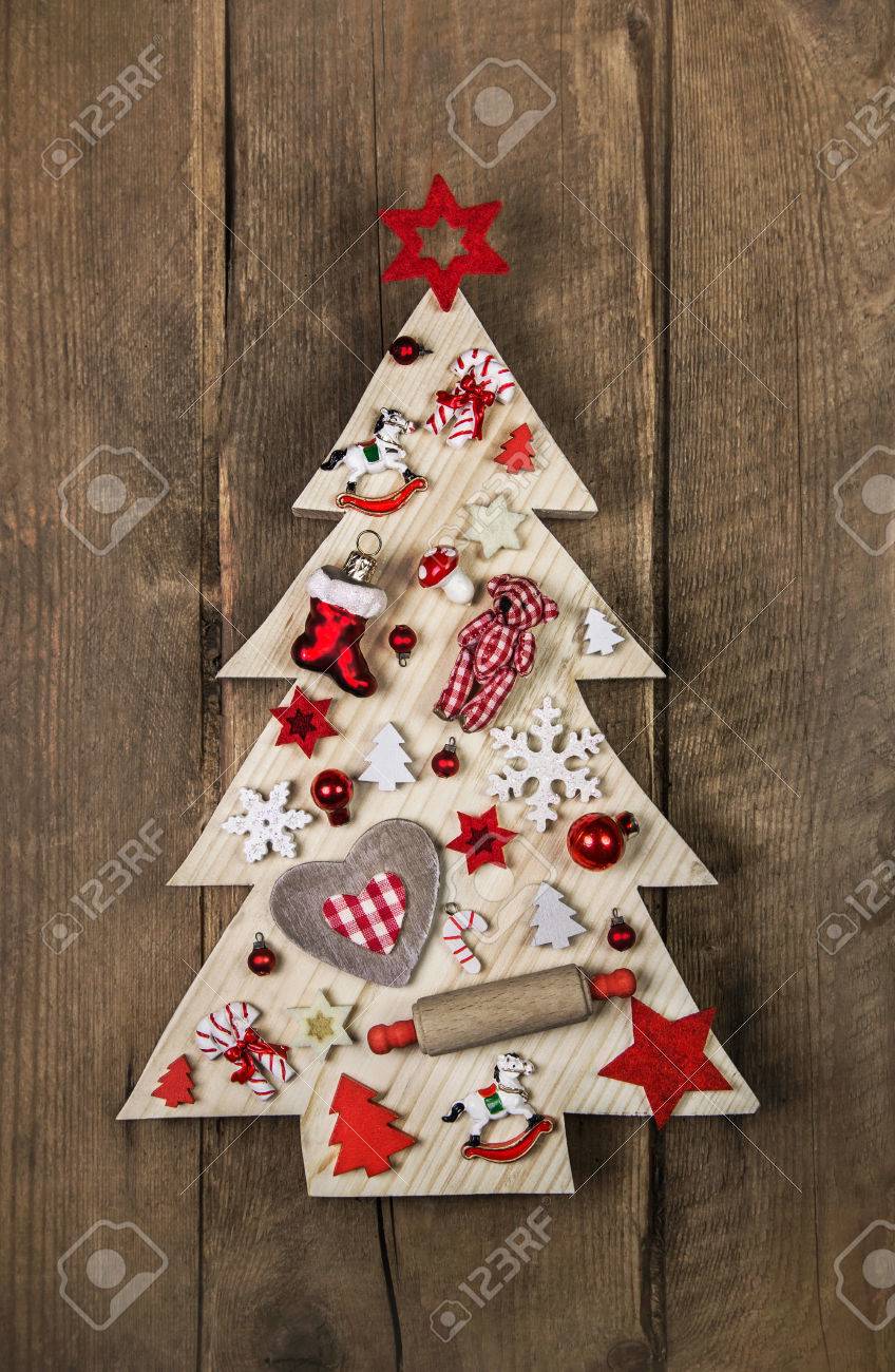 Sapin de Noël fait main en bois dans un style campagnard avec une décoration blanche et rouge.