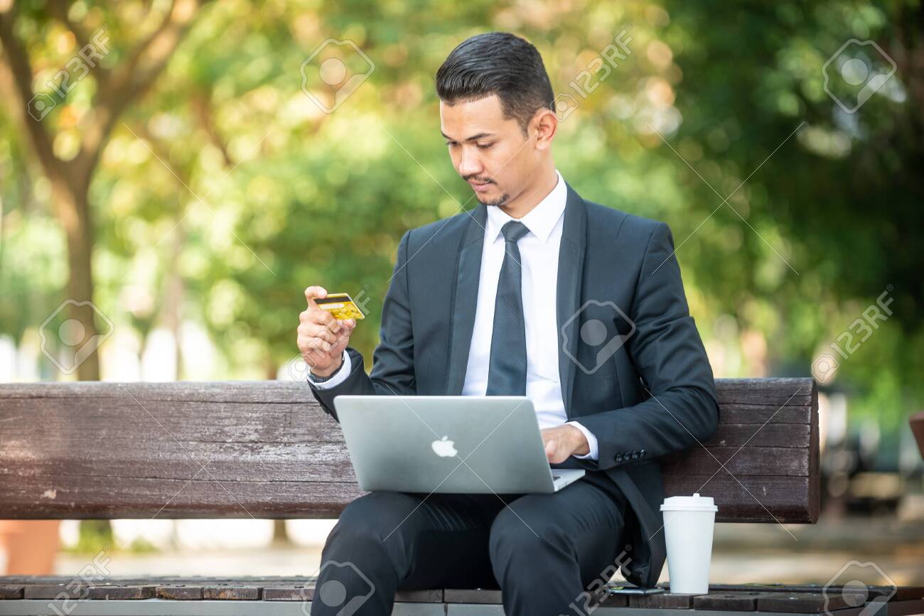 Malay Businessman Doing Online Purchase During His Coffee Break Outdoor Setting Stock Photo Picture And Royalty Free Image Image 129085845