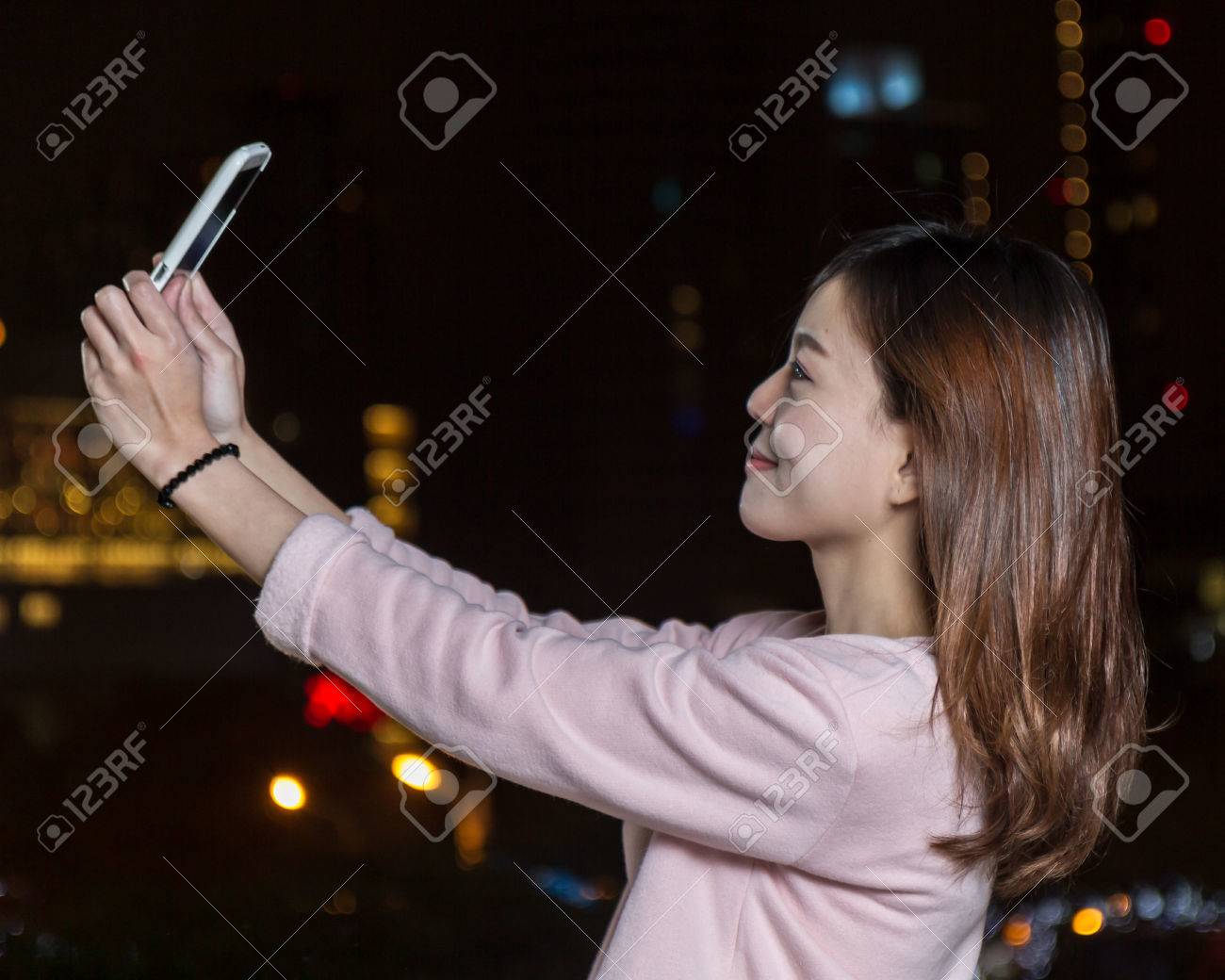 Beautiful Malaysian female with bright lights of city in background - 25019900 Beautiful Malaysian female with bright lights of city in background - 25019900