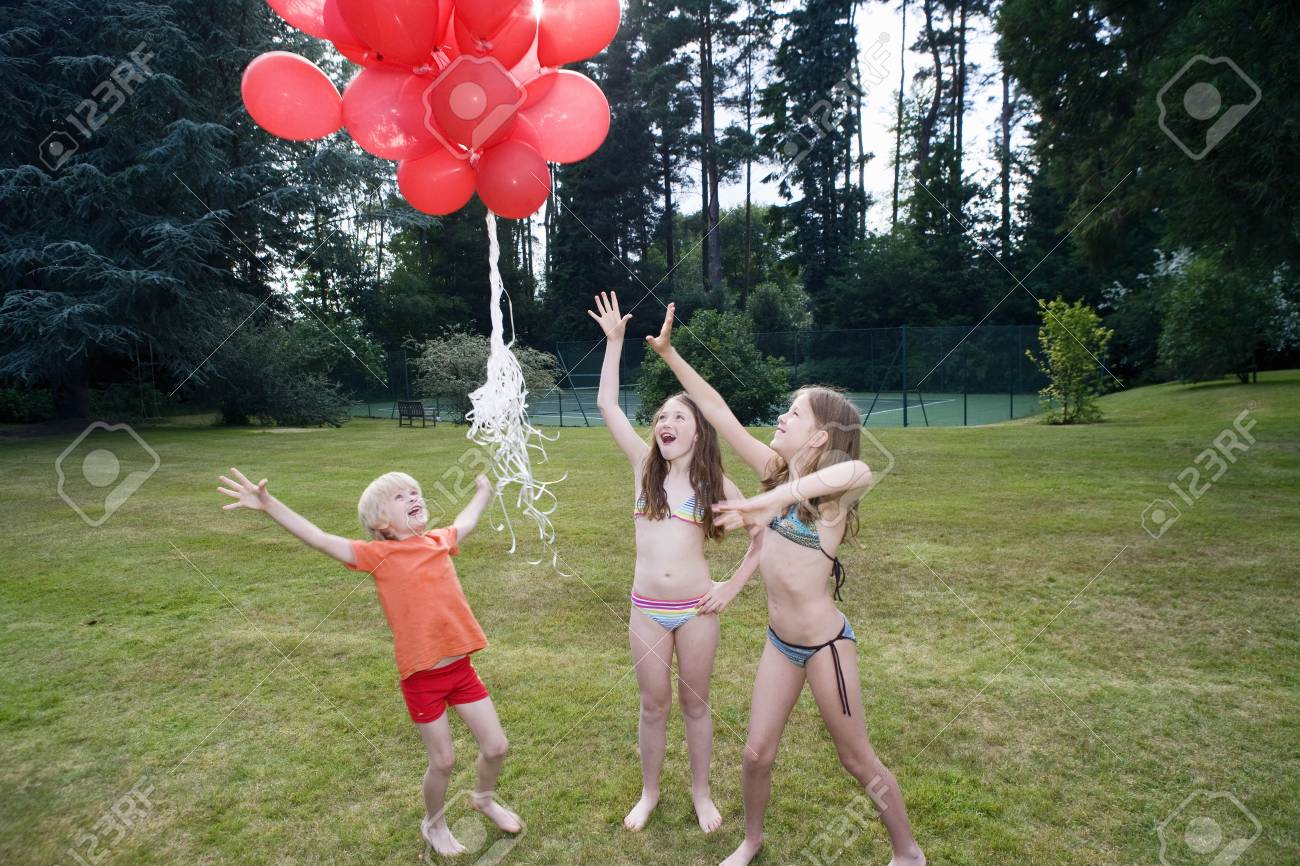 Kids letting red balloons go - 104950369 Kids letting red balloons go - 104950369
