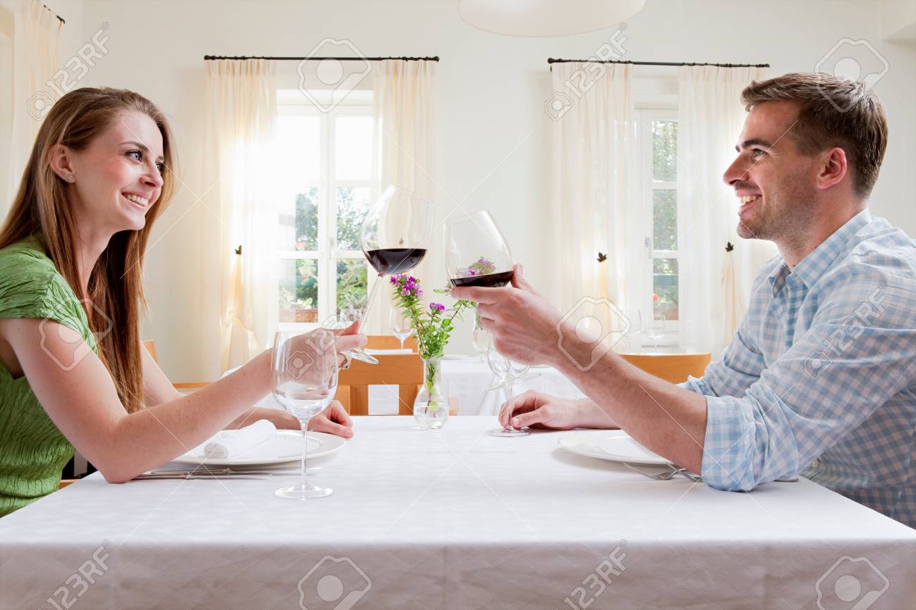 Couple at restaurant toasting with wine - 114160257 Couple at restaurant toasting with wine - 114160257