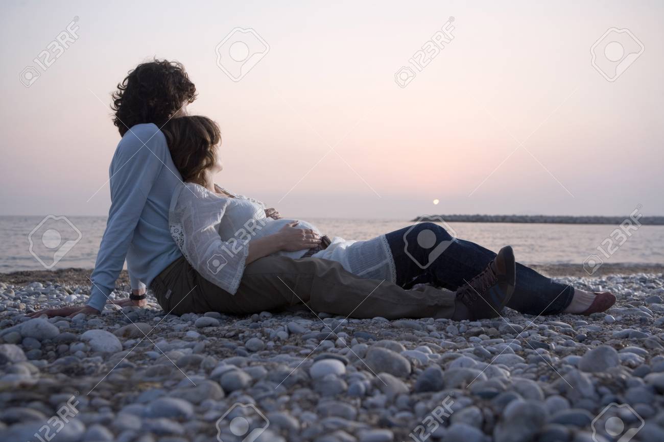 Jeune Couple Allongé Sur La Plage Femme Enceinte Coucher De Soleil