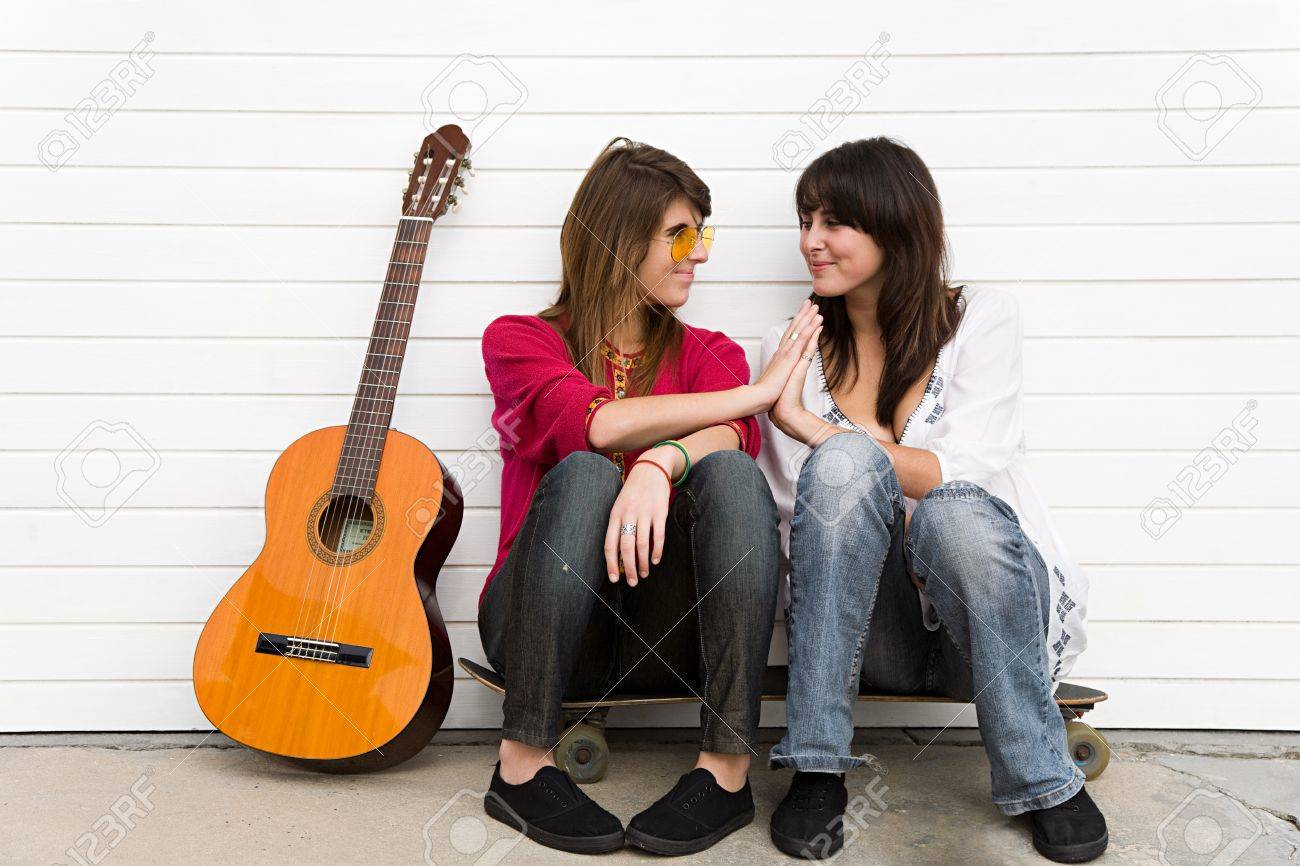 two girls sitting on floor with guitar stock photo picture and