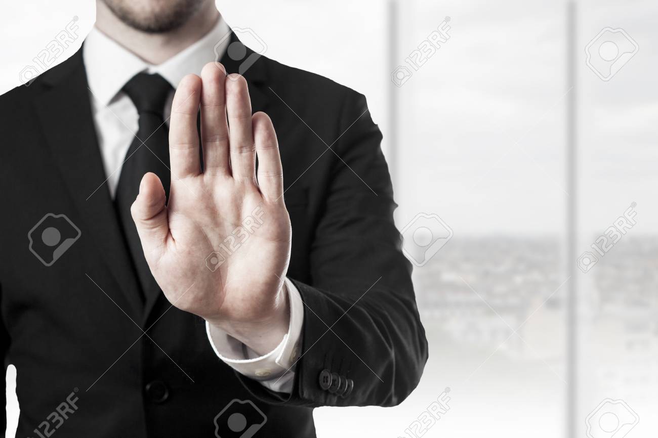 businessman in black suit holding hand stop in office room - 30031871 businessman in black suit holding hand stop in office room - 30031871