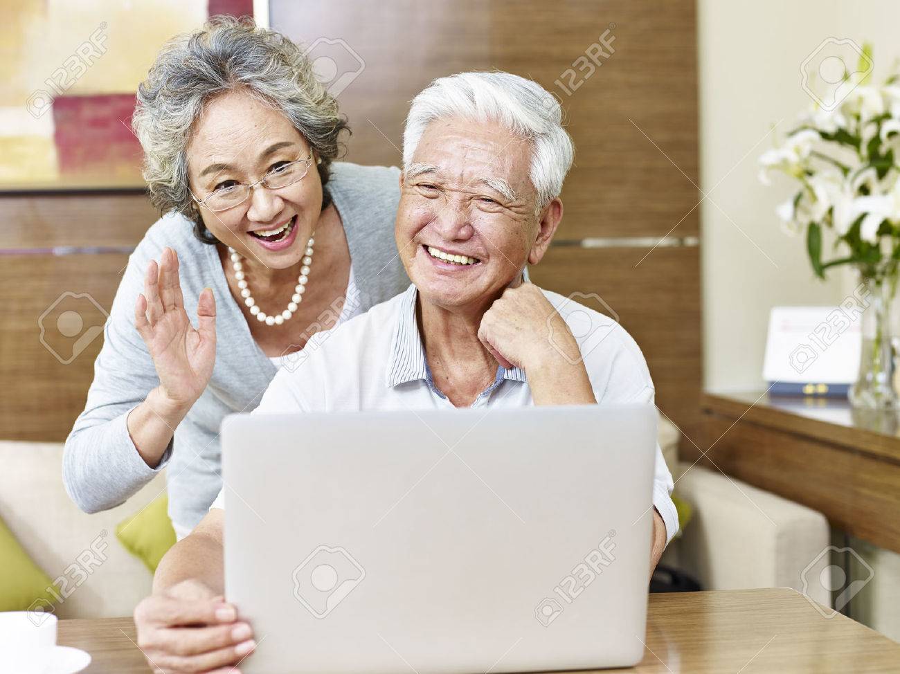 senior asian couple saying hello during a video chatting. - 65936290 senior asian couple saying hello during a video chatting. - 65936290