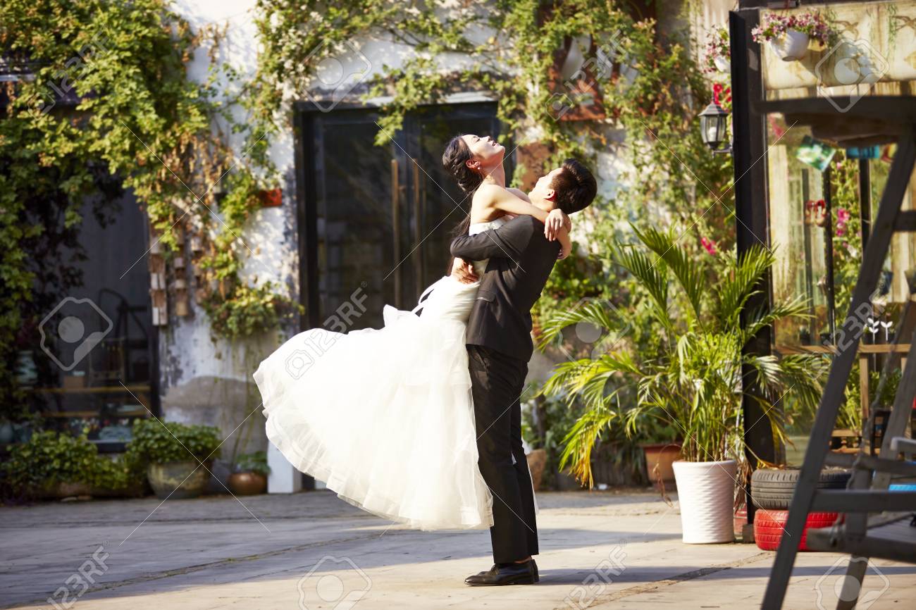 asian newly wed bride and groom celebrating marriage outside a building. - 86053724 asian newly wed bride and groom celebrating marriage outside a building. - 86053724