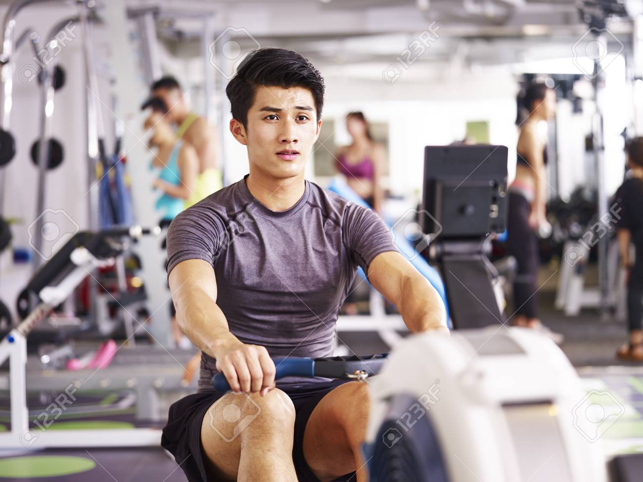 young asian adult man working out in gym using rowing machine. - 87617758 young asian adult man working out in gym using rowing machine. - 87617758