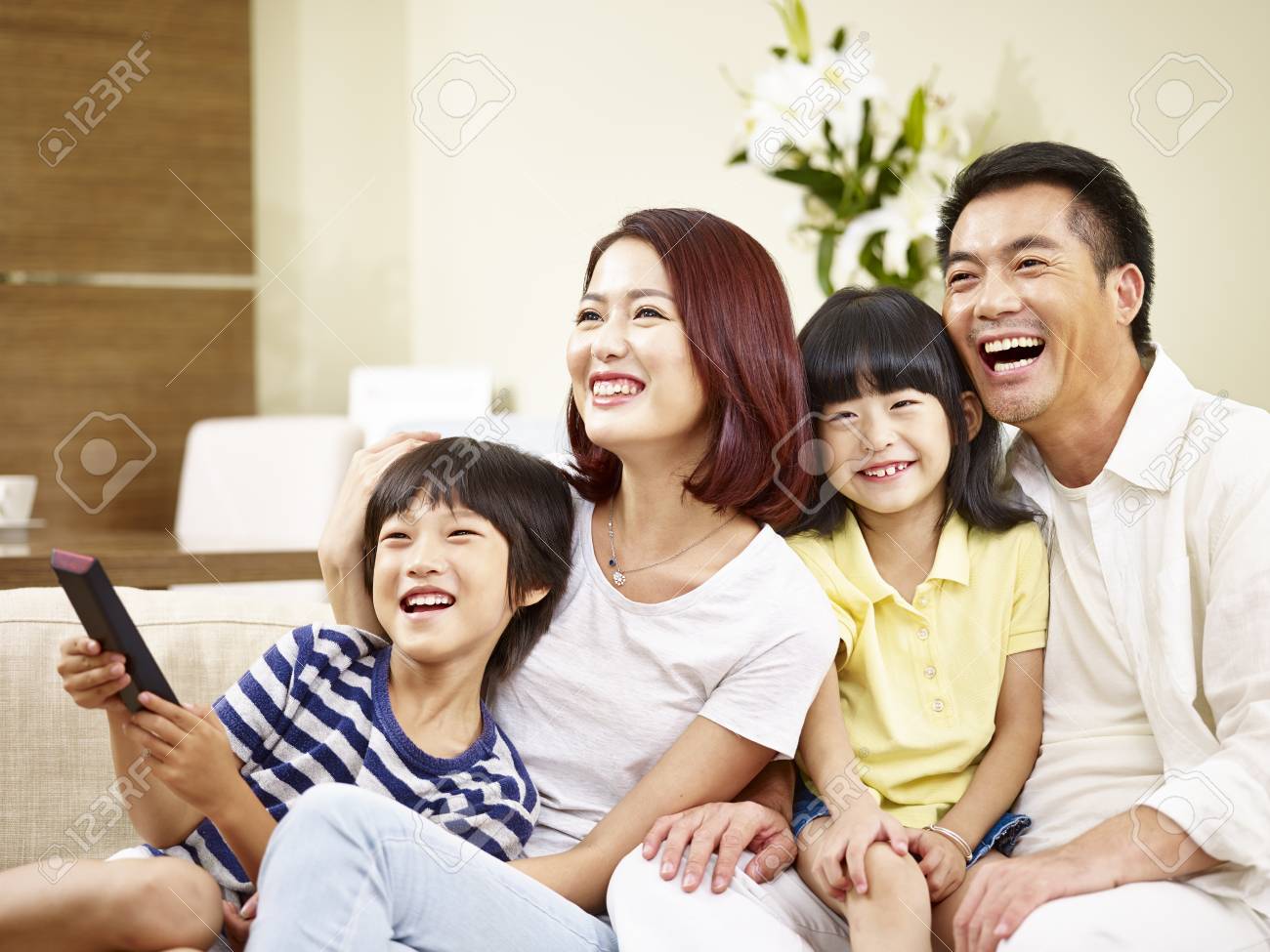happy asian family with two children sitting on couch at home watching TV. - 92705705 happy asian family with two children sitting on couch at home watching TV. - 92705705
