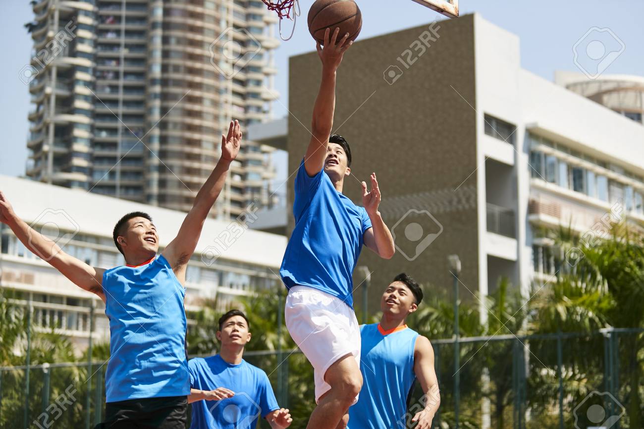young asian adult male player playing basketball on a urban outdoor court. - 103906546 young asian adult male player playing basketball on a urban outdoor court. - 103906546