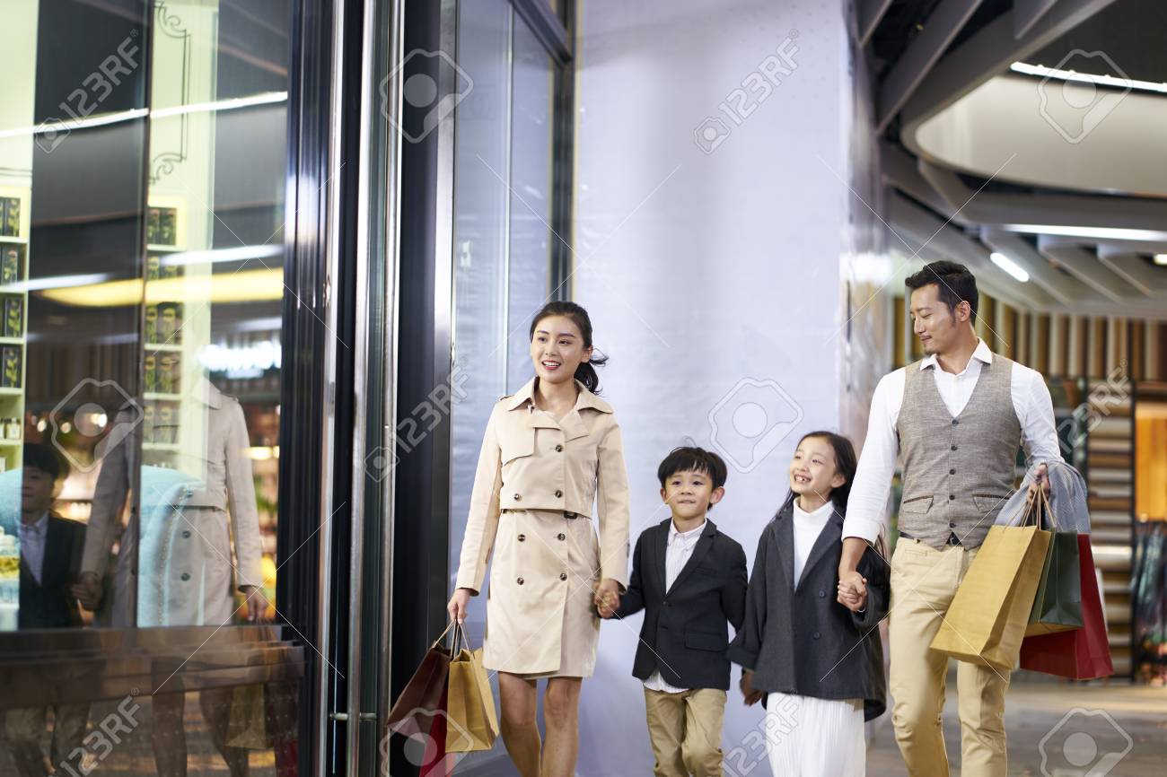 happy asian family with two children walking in shopping mall - 115866245 happy asian family with two children walking in shopping mall - 115866245