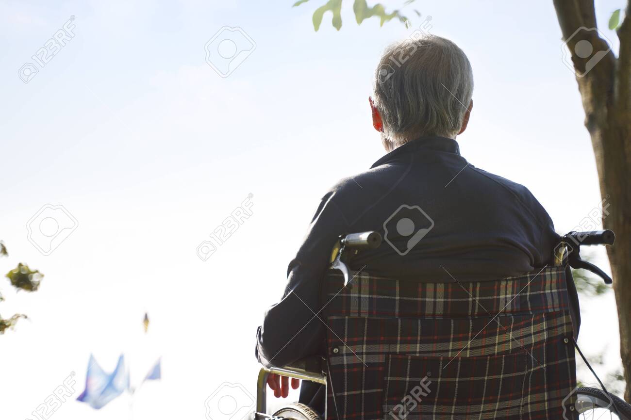 rear view of asian senior man sitting in wheel chair looking at sky - 134599691 rear view of asian senior man sitting in wheel chair looking at sky - 134599691