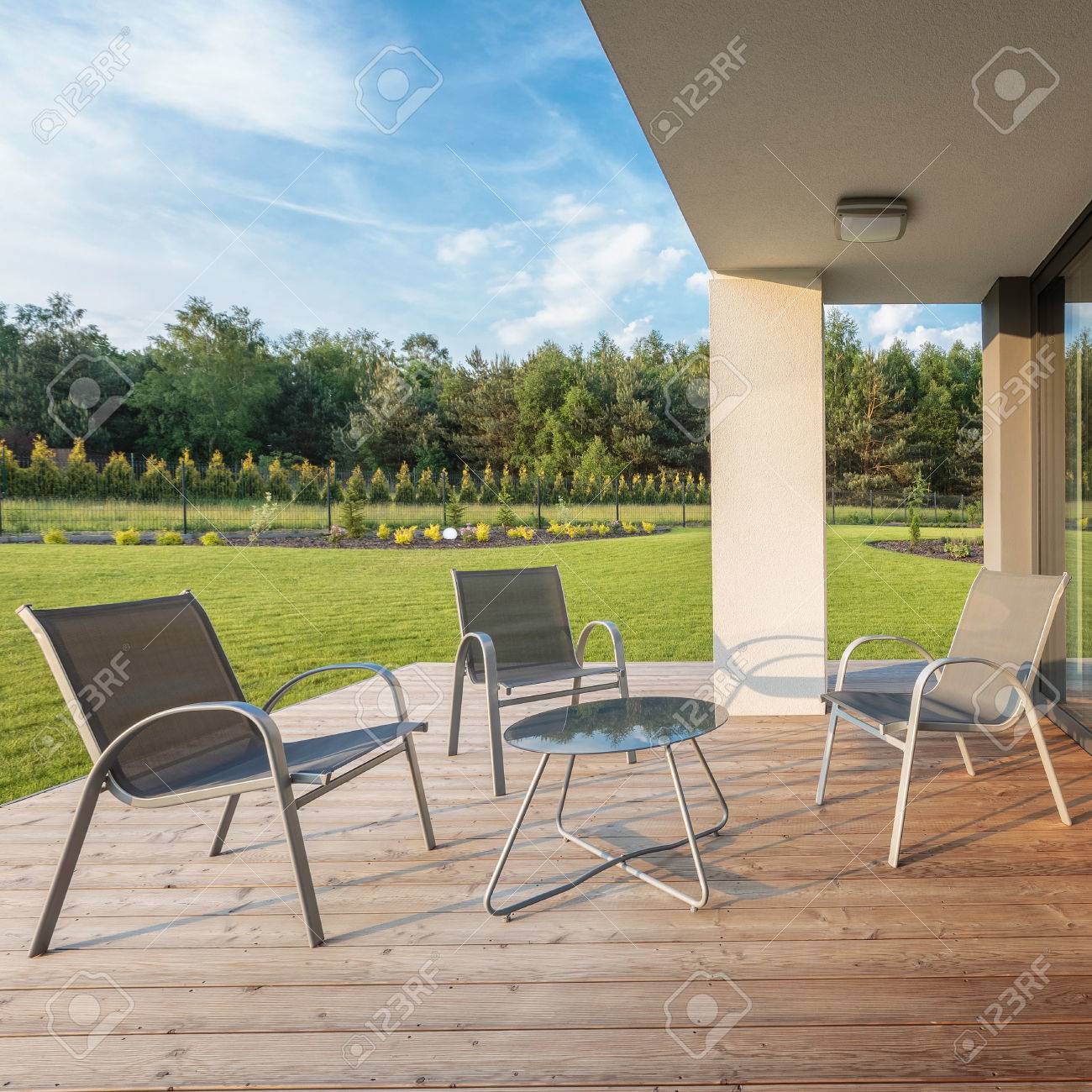 Stilvolle Terrasse Mit Holzboden Und Einfachem Mobelset Mit Schonem Garten Lizenzfreie Fotos Bilder Und Stock Fotografie Image 58747110
