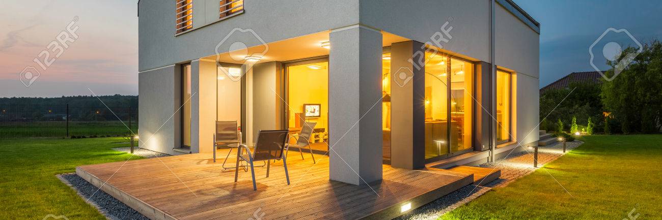 External View Of New House At Night With Lights On Inside And