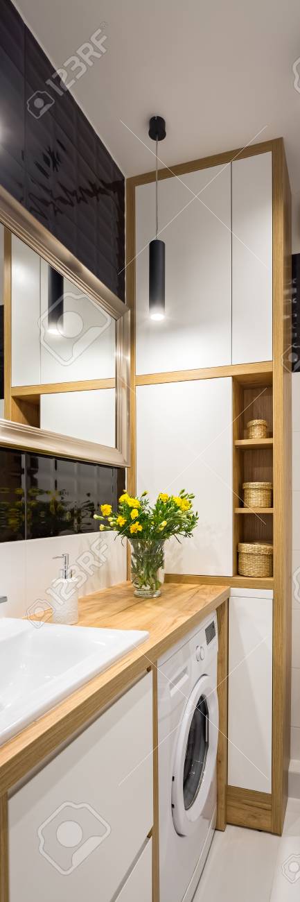 Black And White Bathroom With Wooden Cabinet And Mirror And