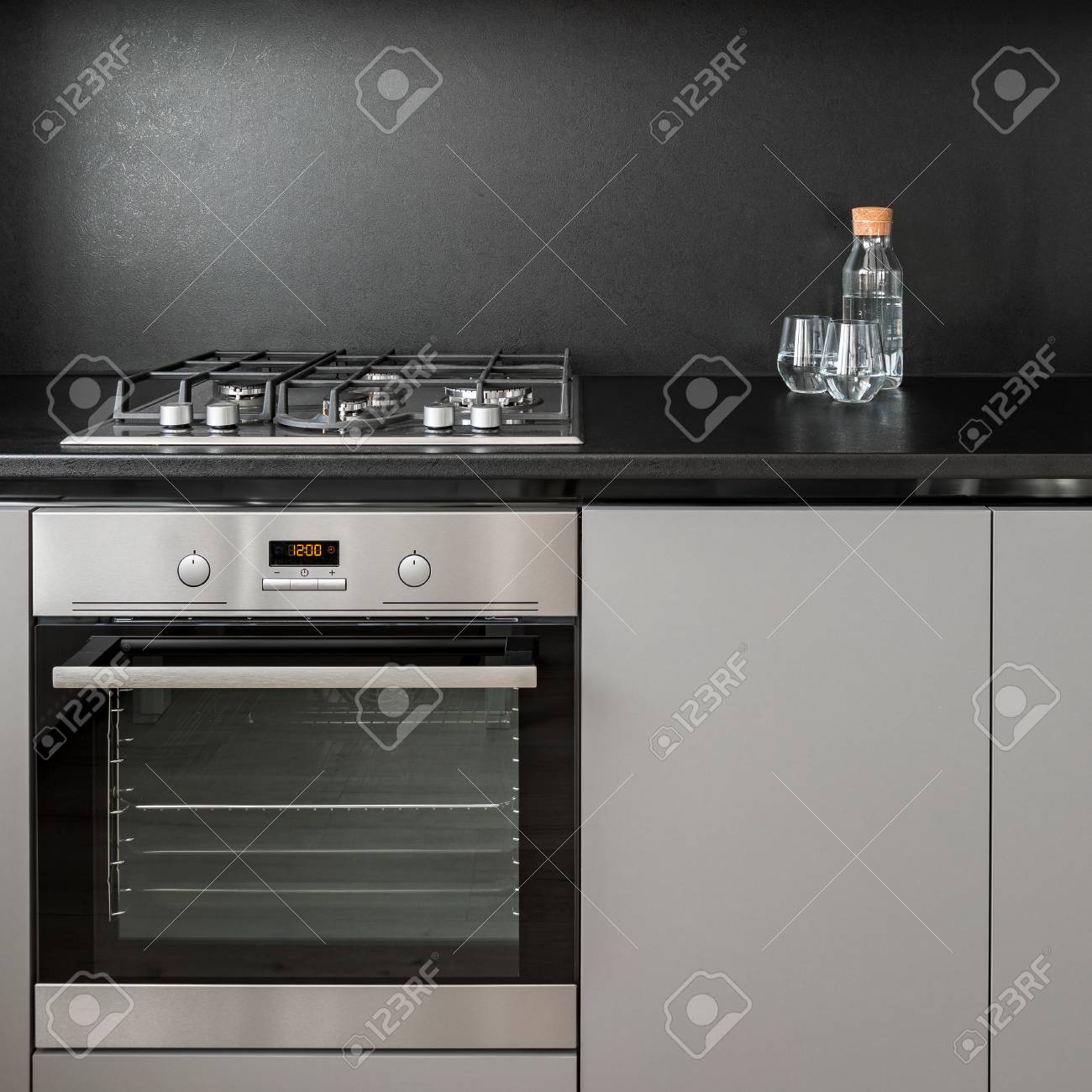 Gray Kitchen Cabinet, Black Backsplash, Oven And Hob Stock Photo - Gray Kitchen Cabinet, Black Backsplash, Oven And Hob Stock Photo