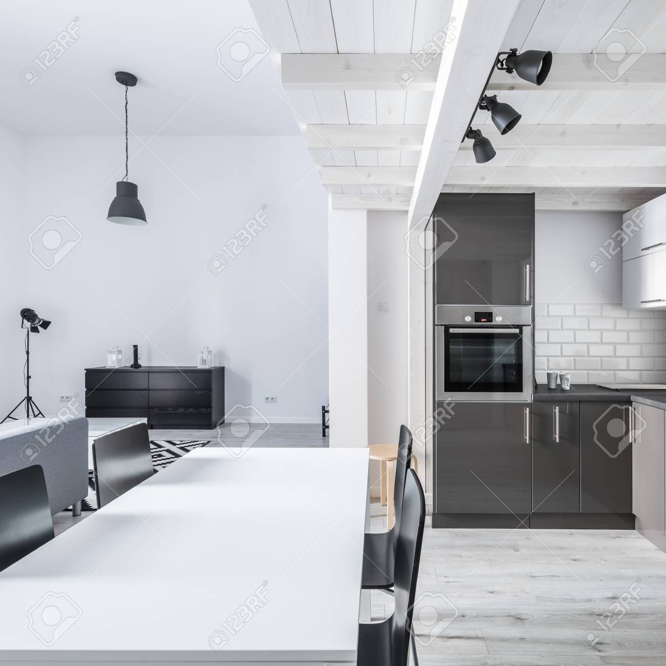 Modern Kitchen With White Dining Table And Black Chairs Stock