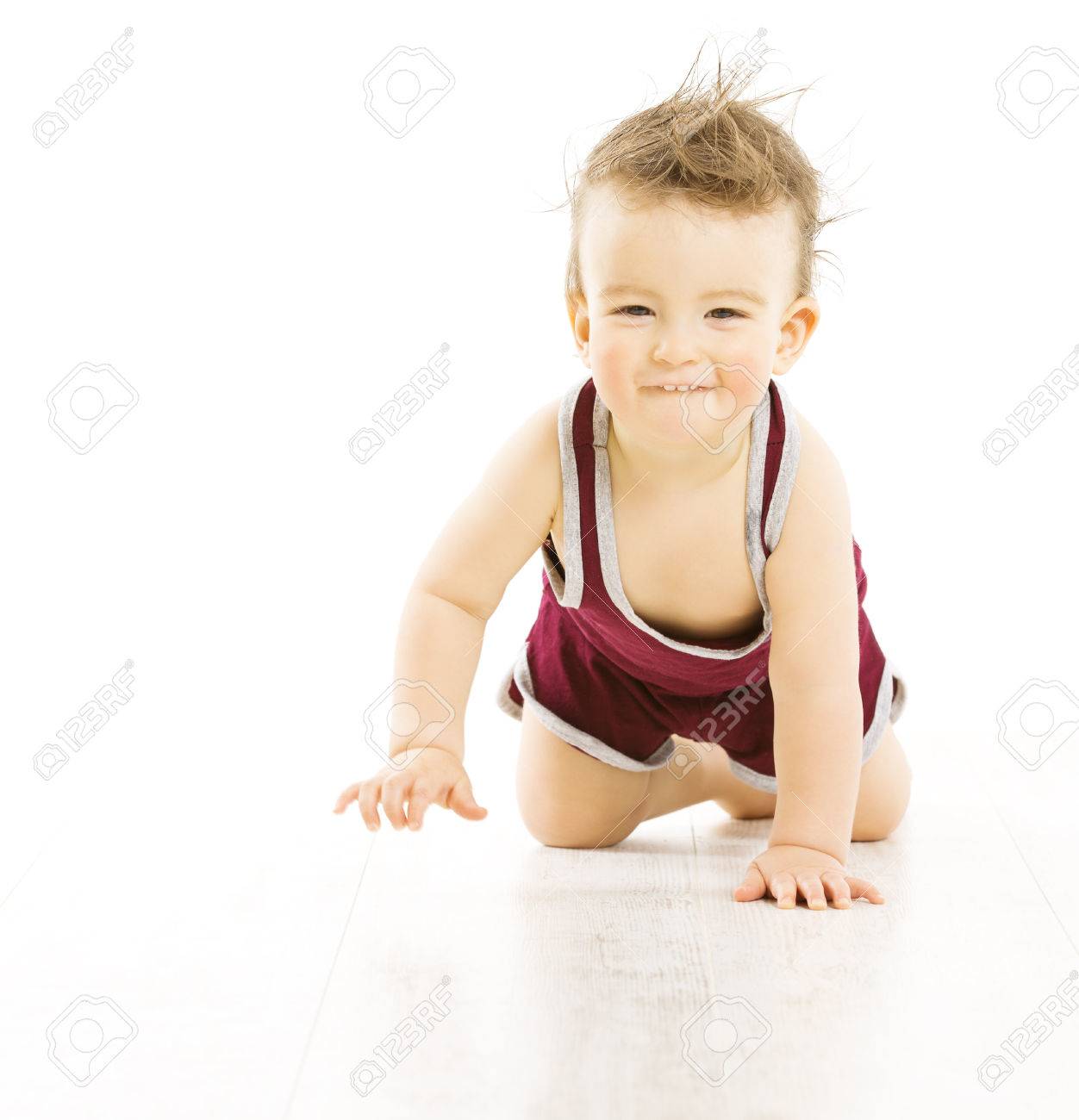 赤ちゃんの幸せな白い背景で隔離のクロール スポーツ スーツのアクティブ逆立つの男の子ボサボサ髪の毛に笑みを浮かべて の写真素材 画像素材 Image