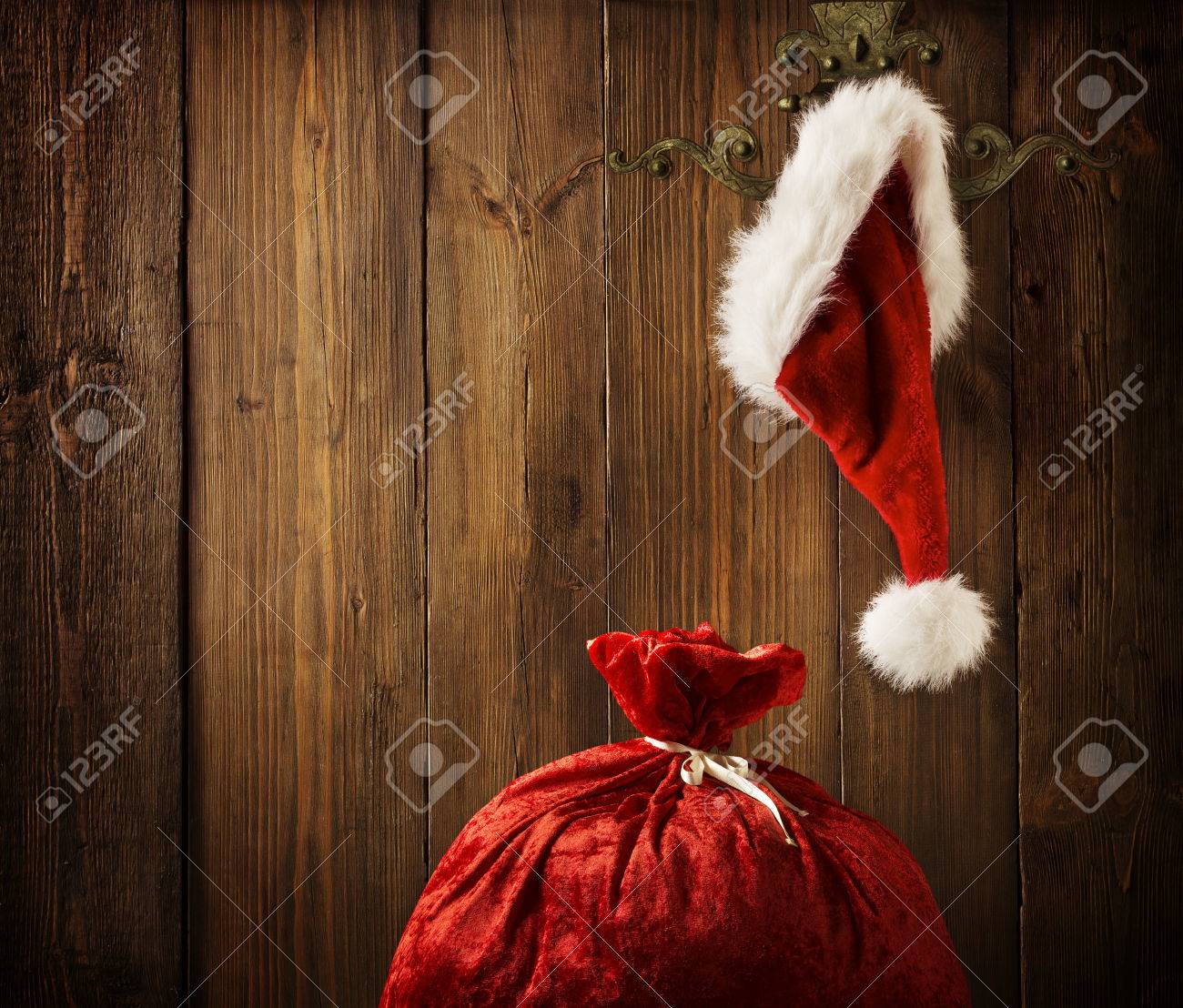 Christmas Santa Claus Hat Hanging On Wood Wall, Xmas Concept, Decoration Over Grunge Wooden Background - 33657183 Christmas Santa Claus Hat Hanging On Wood Wall, Xmas Concept, Decoration Over Grunge Wooden Background - 33657183