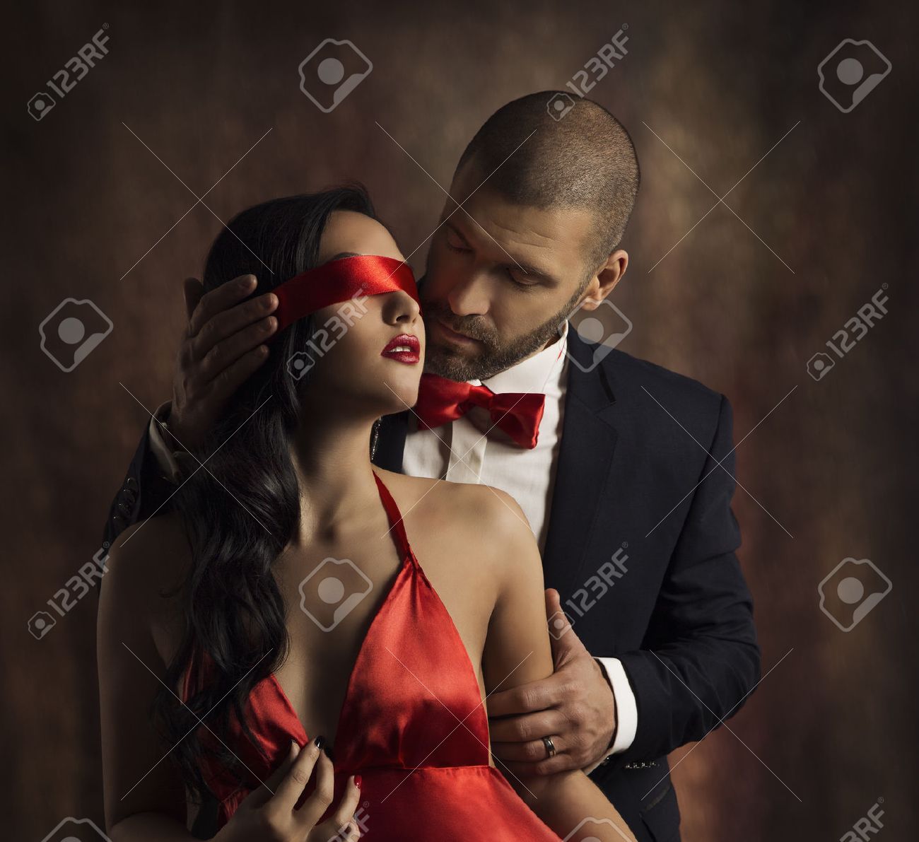 セクシーなカップルは愛のキス 官能的な女性 少女の目に赤いファッション目隠しキス スーツの男 の写真素材 画像素材 Image